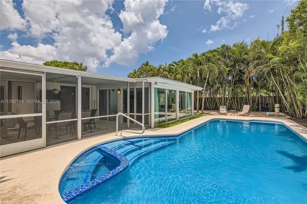 a view of a house with a swimming pool and wooden fence