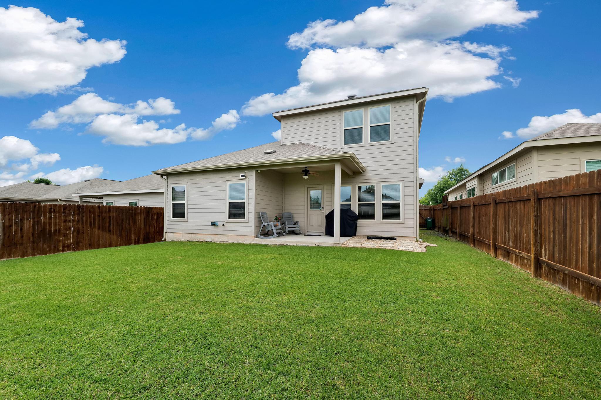 6905 Vail Ridge Street Austin, TX 78744 - Photo 27 of 39 Expansive backyard featuring a manicured lawn and privacy fence