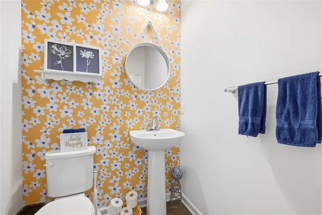 a bathroom with a sink a mirror a toilet and a mirror