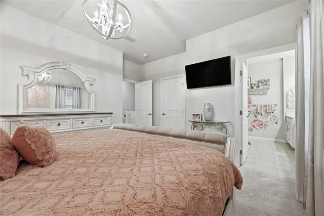 a bedroom with a bed mirror on desk and a window