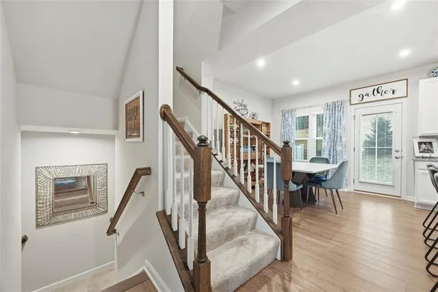 a view of staircase with lots of furniture and wooden floor