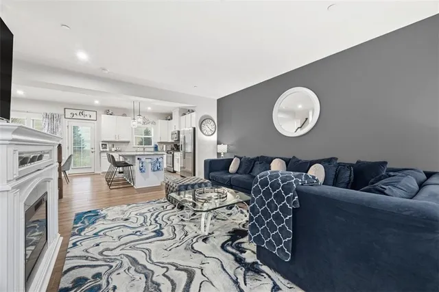 a living room with furniture kitchen view and a flat screen tv