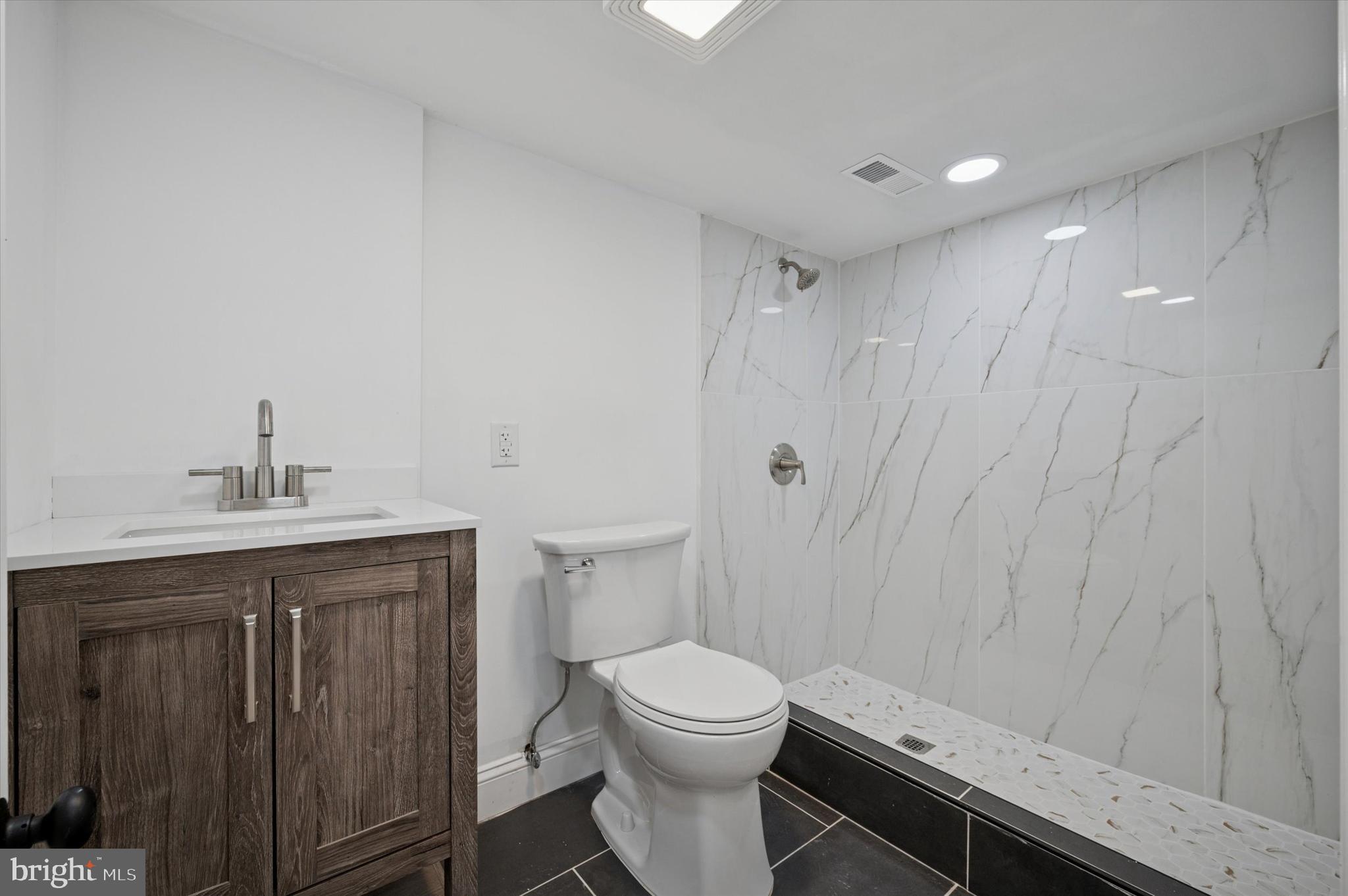 5617 Walton Avenue Philadelphia, PA 19143 - Photo 21 of 28 a bathroom with a toilet a sink and shower