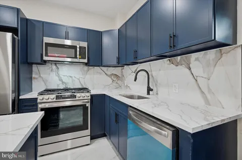 a kitchen with stainless steel appliances granite countertop a sink stove and microwave