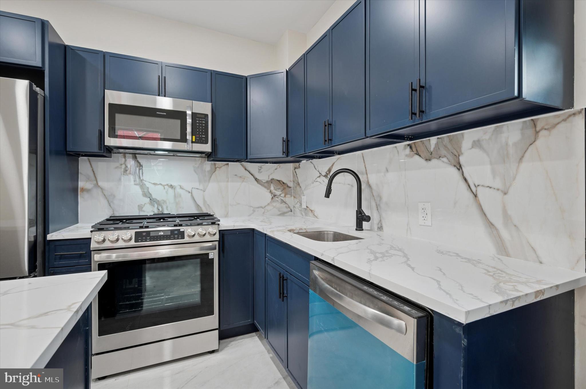 5617 Walton Avenue Philadelphia, PA 19143 - Photo 4 of 28 a kitchen with stainless steel appliances granite countertop a sink stove and microwave