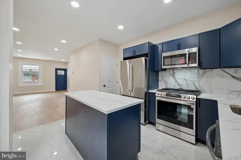 a kitchen with stainless steel appliances granite countertop a stove top oven microwave and refrigerator
