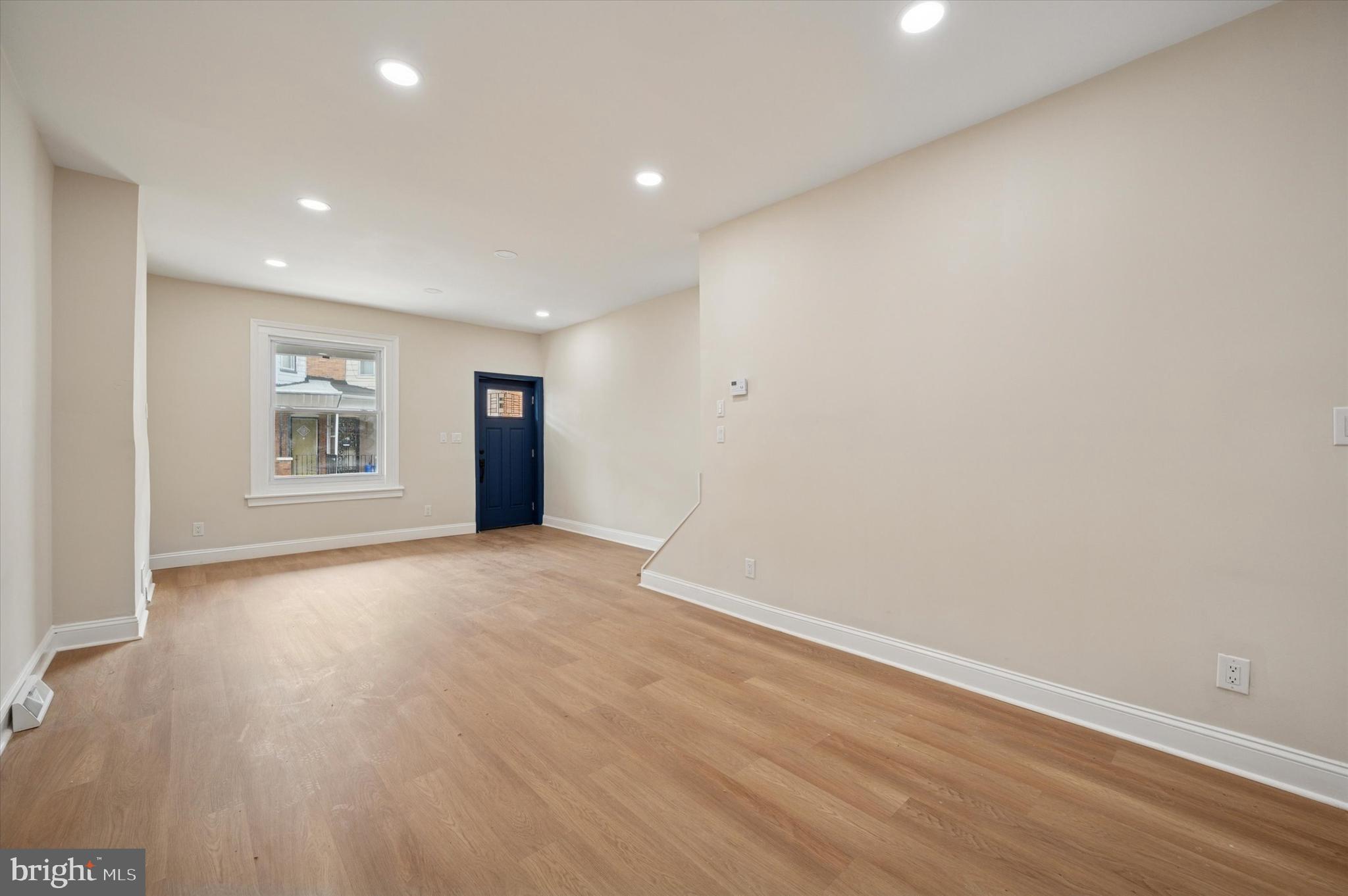5617 Walton Avenue Philadelphia, PA 19143 - Photo 10 of 28 a view of an empty room with a window and wooden floor