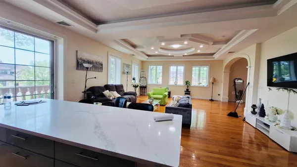 a living room with furniture flat screen tv and a chandelier