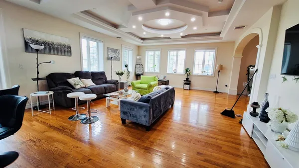 a living room with furniture flat screen tv and wooden floor