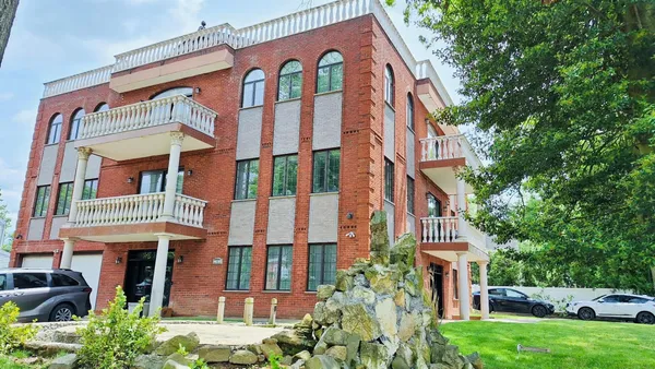 a kitchen with stainless steel appliances kitchen island granite countertop a refrigerator a sink a stove and white cabinets with wooden floor