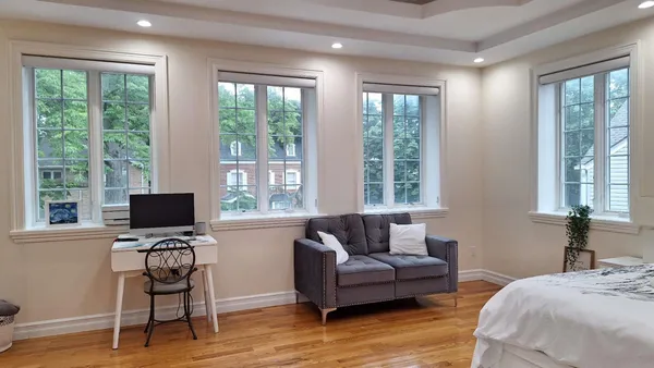 a spacious bedroom with a bed a mirror and a window