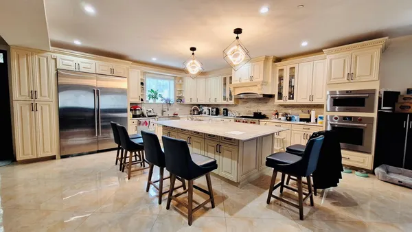 a kitchen with kitchen island a stove a table and chairs in it
