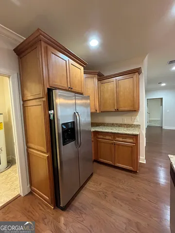 a kitchen with granite countertop a refrigerator stove and sink