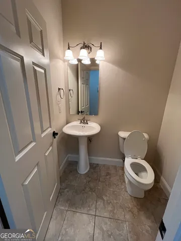 a bathroom with a toilet a sink and mirror