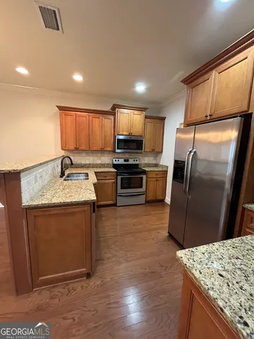 a kitchen with granite countertop a sink stove and refrigerator