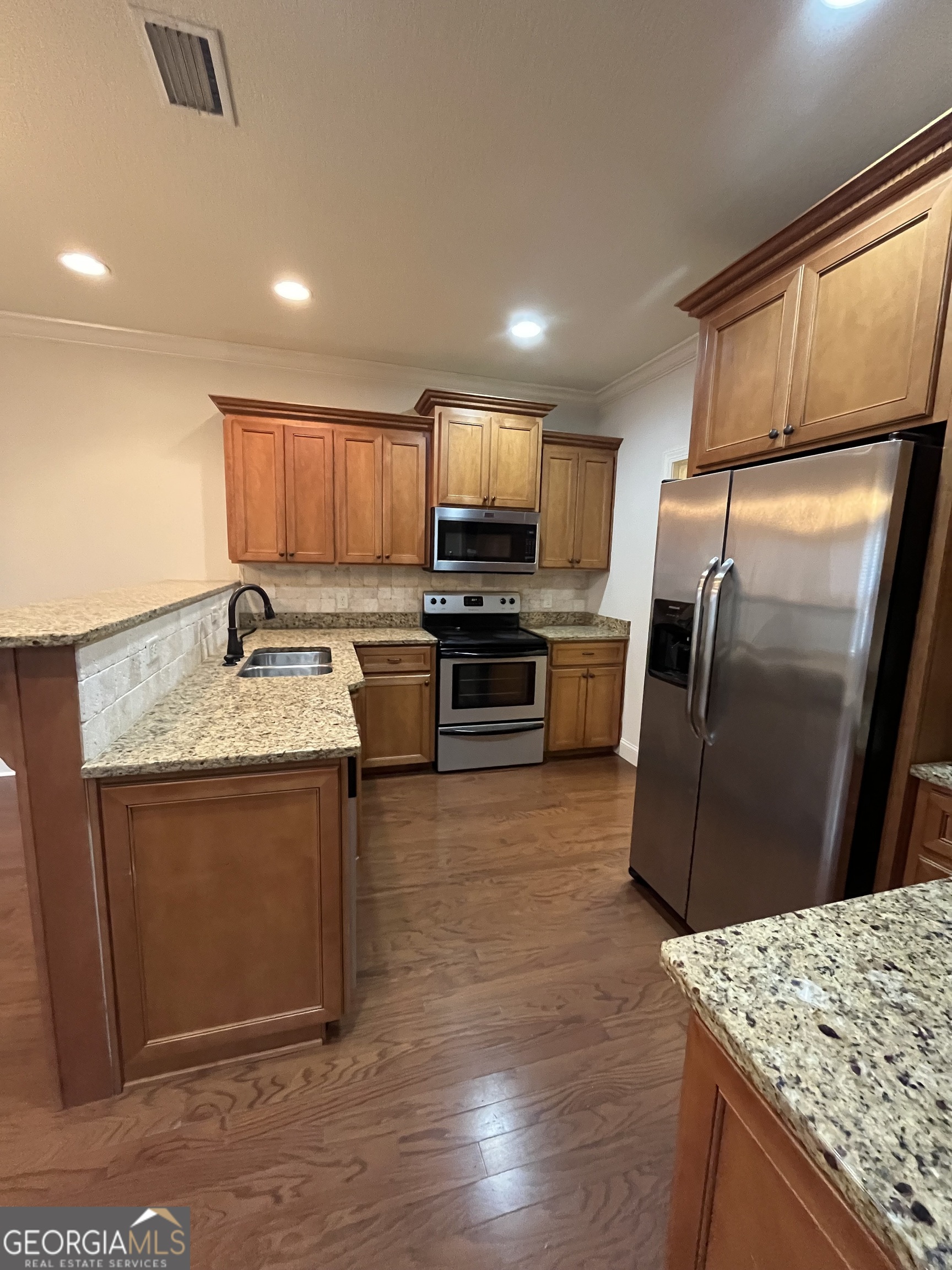 708 Osborne Street, Unit 206 St. Marys, GA 31558 - Photo 10 of 27 a kitchen with granite countertop a sink stove and refrigerator