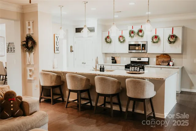 a view of kitchen with stainless steel appliances granite countertop a sink a stove and a refrigerator