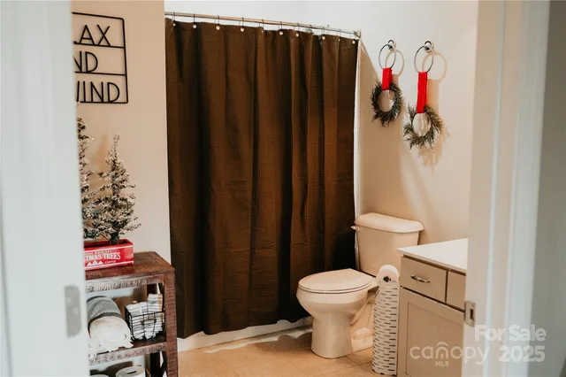 a bathroom with a toilet and a shower curtain