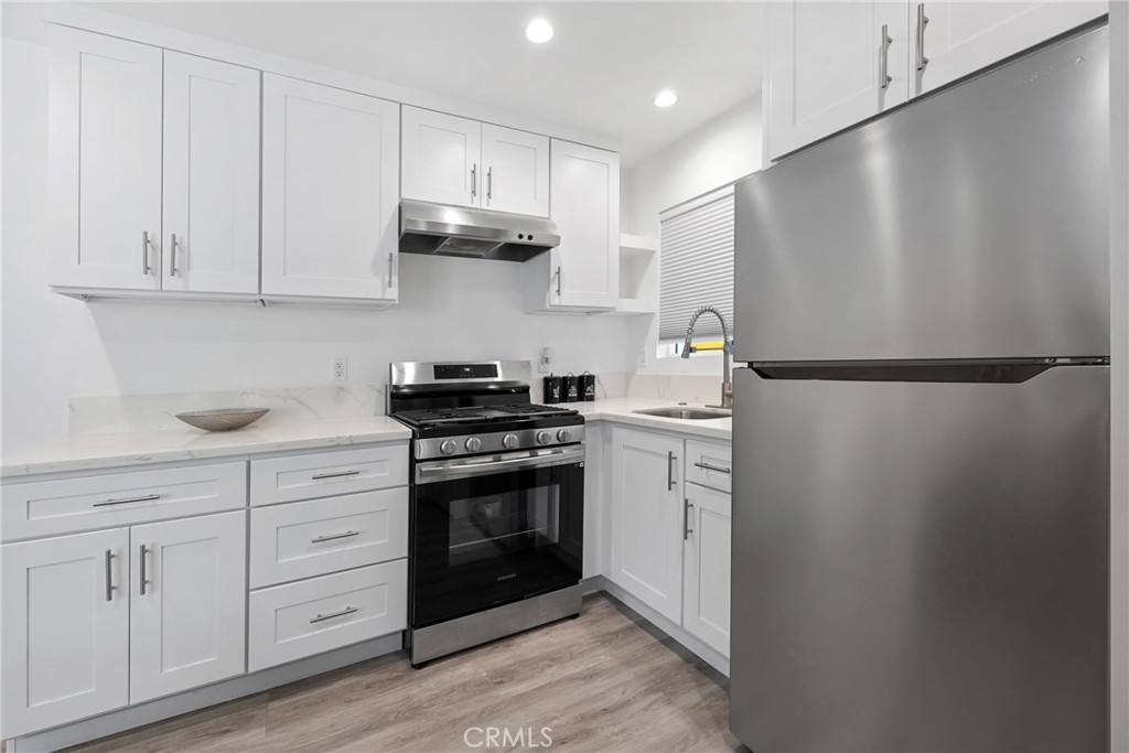 18017 Collins Street Encino, CA 91316 - Photo 3 of 10 a kitchen with white cabinets and white appliances