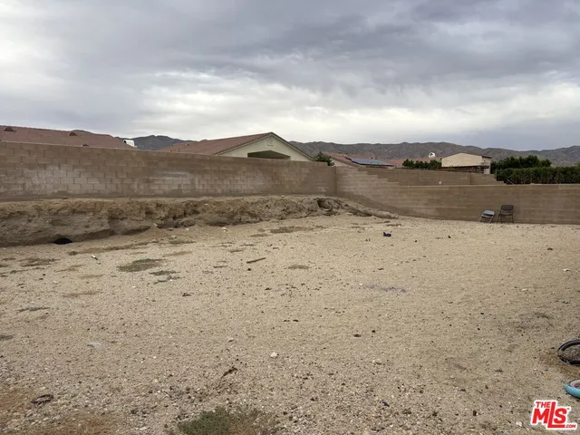 a view of dirt road with large trees