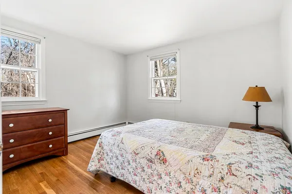 a bedroom with a bed and a lamp on dresser