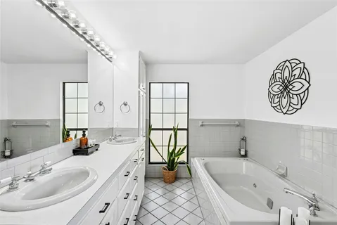 a bathroom with a tub sink and mirror