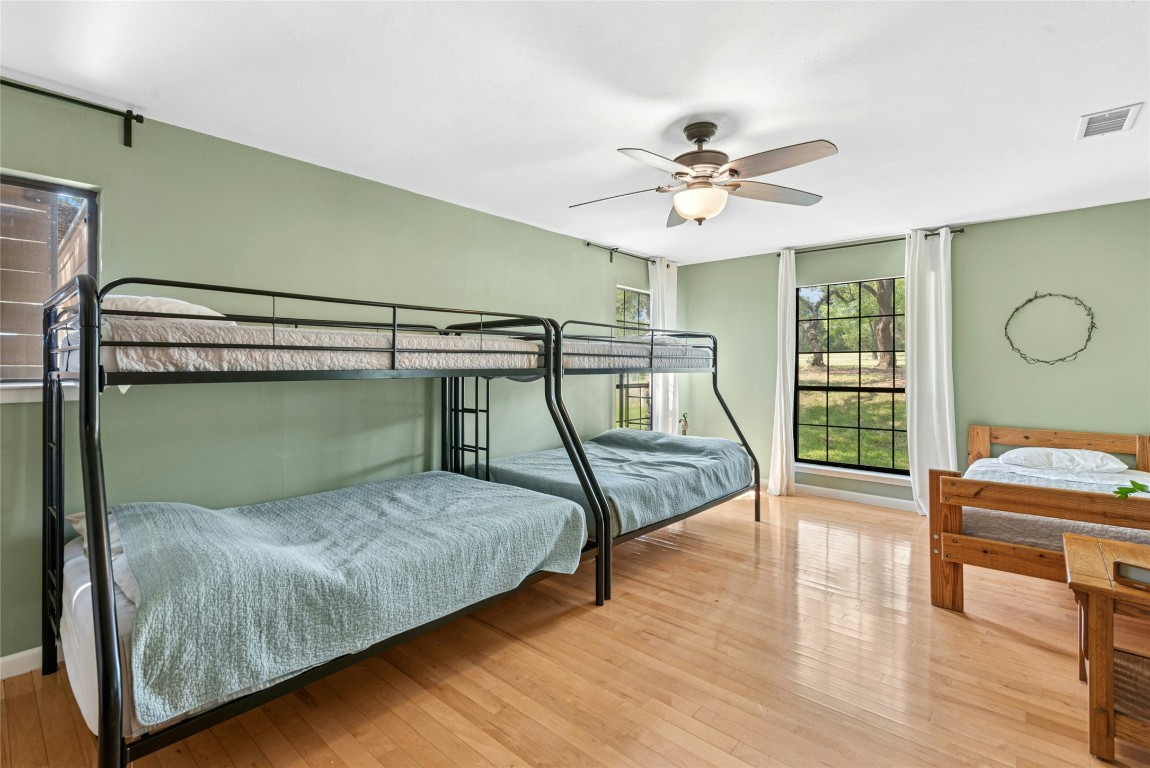 110 Longhorn Lane Dripping Springs, TX 78620 - Photo 15 of 40 a bedroom with a bed and a chandelier