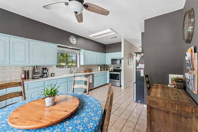 a kitchen with stainless steel appliances granite countertop a sink refrigerator and cabinets