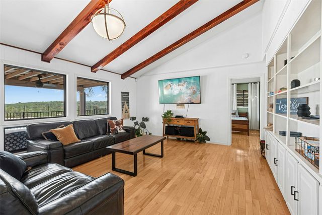 a living room with furniture a fireplace and large windows