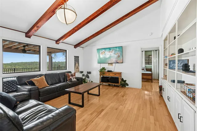 a living room with furniture a fireplace and large windows