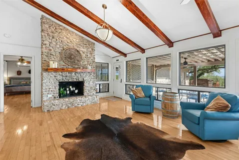a living room with furniture a fireplace and a floor to ceiling window