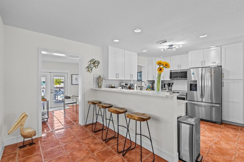 3391 Mangrove Drive Hernando Beach, FL 34607 - Photo 22 of 52 a kitchen with stainless steel appliances granite countertop a refrigerator and a stove top oven with wooden floor