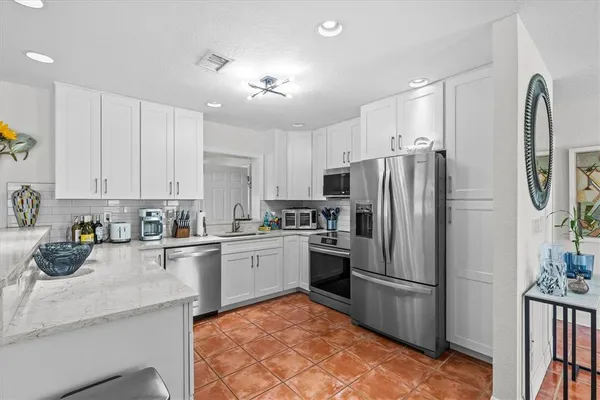 a kitchen with stainless steel appliances a refrigerator sink and cabinets