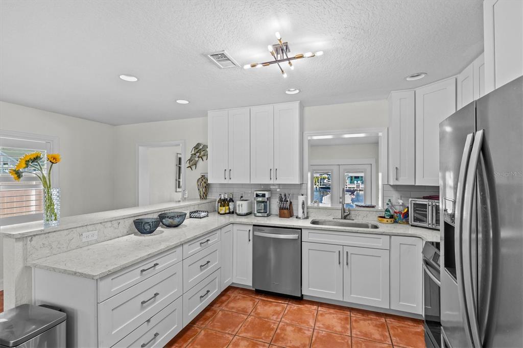 3391 Mangrove Drive Hernando Beach, FL 34607 - Photo 25 of 52 a kitchen with a sink stainless steel appliances and white cabinets
