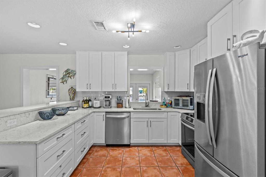 3391 Mangrove Drive Hernando Beach, FL 34607 - Photo 26 of 52 a kitchen with a sink a refrigerator and cabinets