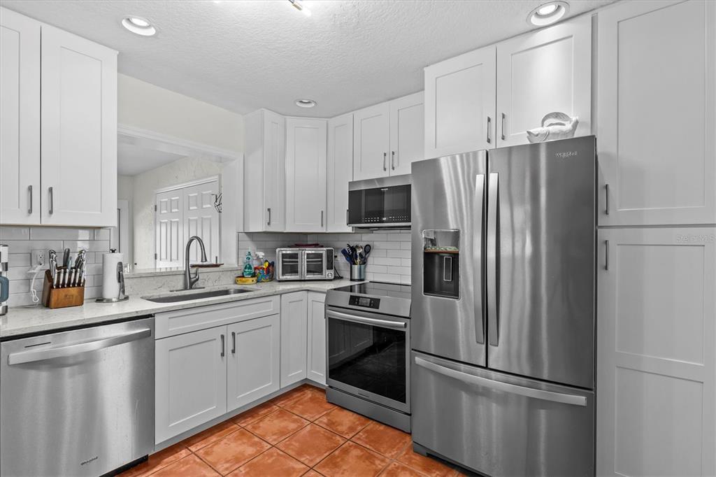 3391 Mangrove Drive Hernando Beach, FL 34607 - Photo 27 of 52 a kitchen with stainless steel appliances a refrigerator sink and cabinets