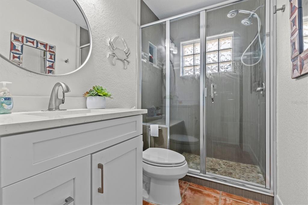 3391 Mangrove Drive Hernando Beach, FL 34607 - Photo 40 of 52 a bathroom with a shower sink vanity mirror and toilet