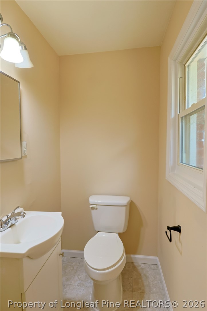 3315 Nato Road Fayetteville, NC 28306 - Photo 21 of 28 a bathroom with a sink a toilet and a mirror