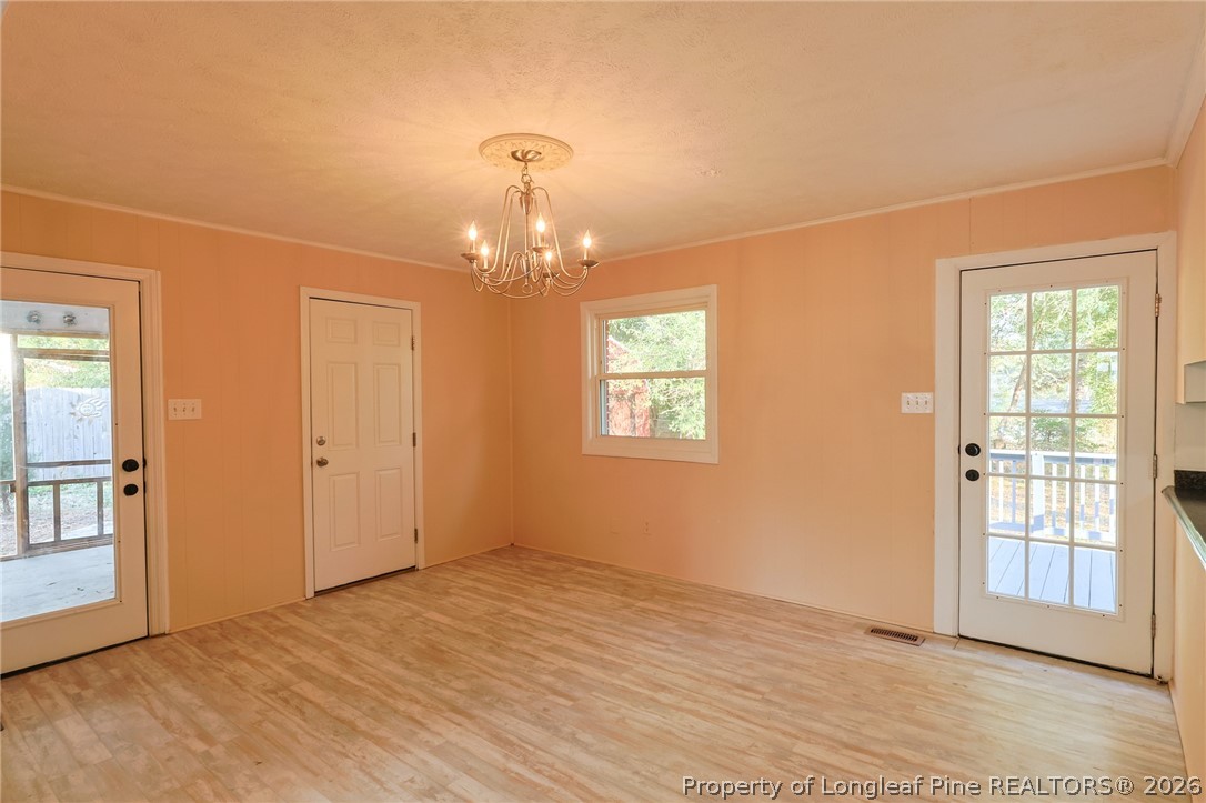 3315 Nato Road Fayetteville, NC 28306 - Photo 8 of 28 an empty room with wooden floor chandelier and windows