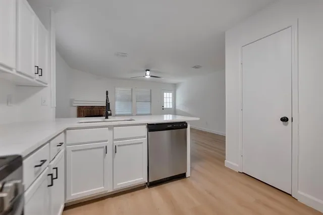 a kitchen with white cabinets and sink