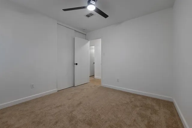 an empty room with a chandelier fan