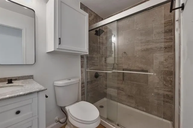 a bathroom with a shower a toilet and sink