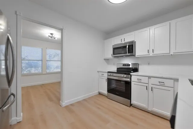 a kitchen with stainless steel appliances granite countertop a stove a sink and a microwave