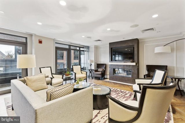 a bedroom with a bed and dresser with wooden floor