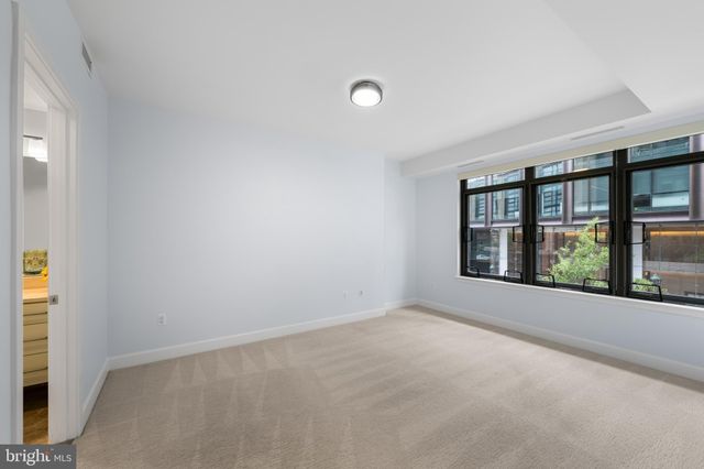 an empty room with windows and plants