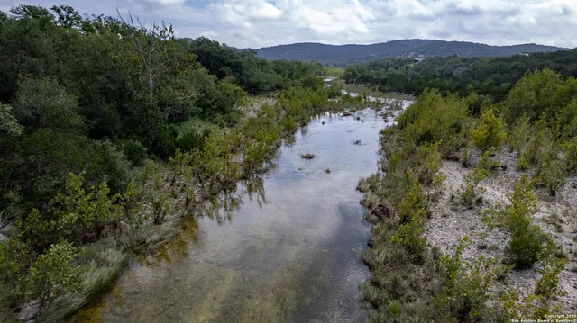 an aerial view of green landscape with trees houses and mountain view