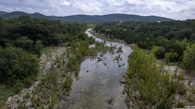 an aerial view of green landscape with trees houses and mountain view