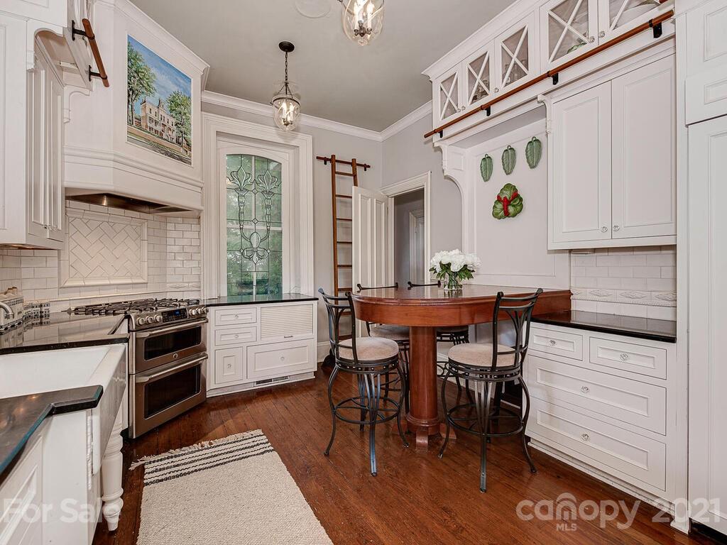 1700 Queens Road Charlotte, NC 28207 - Photo 14 of 48 a kitchen with stainless steel appliances kitchen island granite countertop a table chairs stove and cabinets