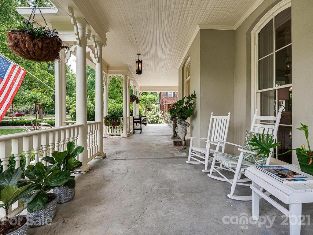 1700 Queens Road Charlotte, NC 28207 - Photo 3 of 48 a porch with a table and chairs and potted plants