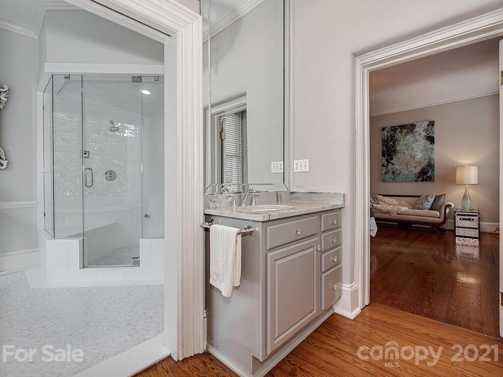 1700 Queens Road Charlotte, NC 28207 - Photo 29 of 48 a bathroom with a granite countertop sink a mirror and shower